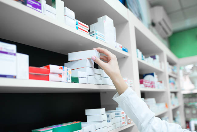 closeup-view-pharmacist-hand-taking-medicine-box-from-shelf-drug-store